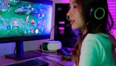 Chica utilizando un ordenador de sobremesa representando plataformas digitales y gaming online